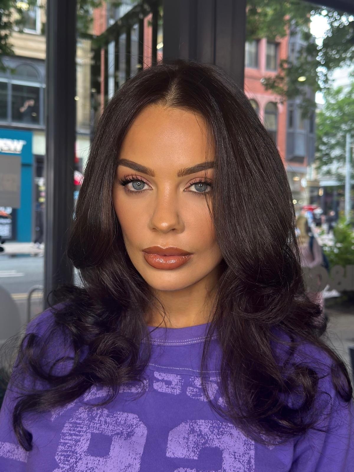 Client with voluminous dark waves, soft pink eyes and a glossy caramel lip