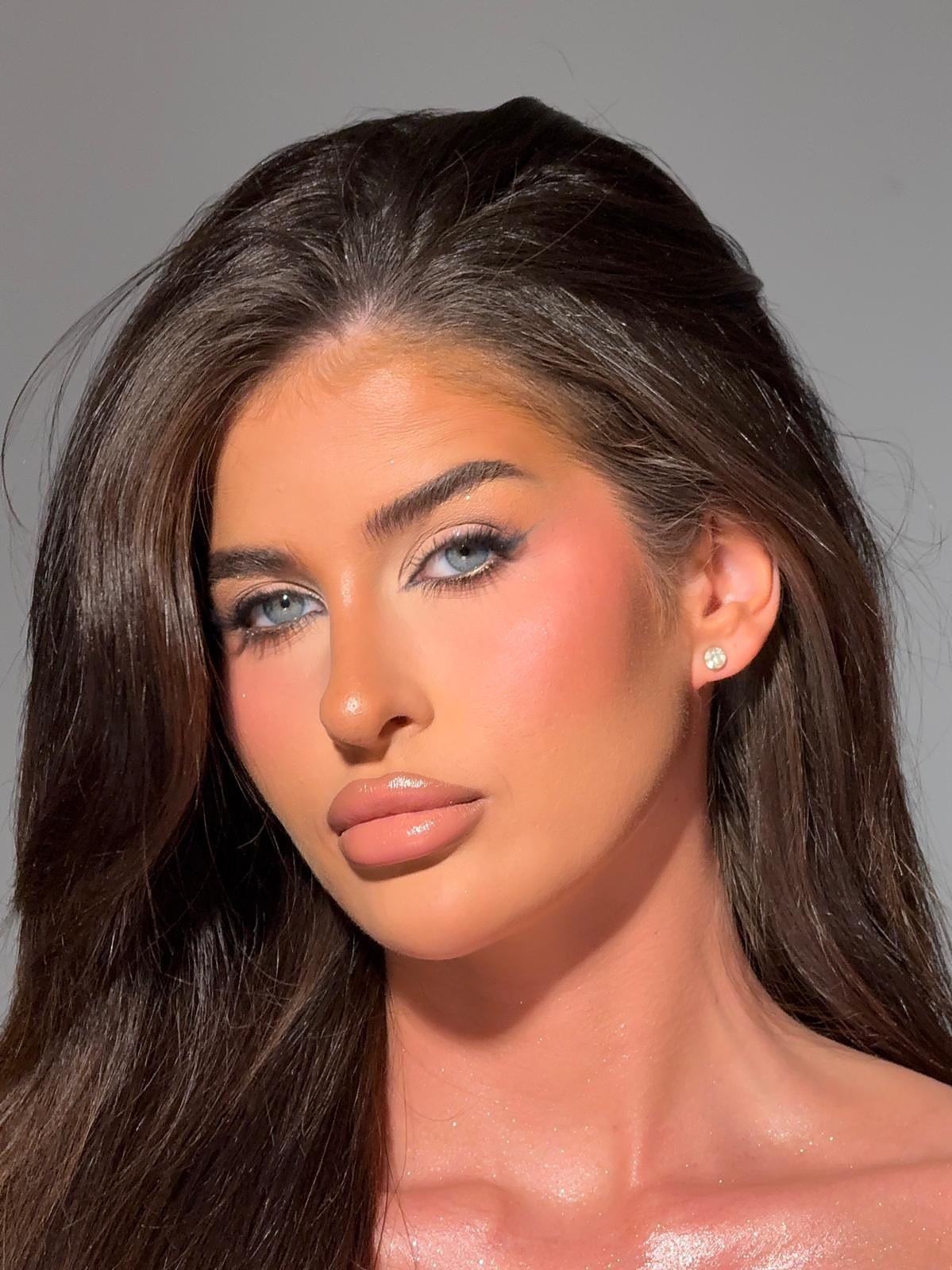 Occasion makeup look: client with sleek dark hair, soft blue liner with a touch of glitter and a peachy blush